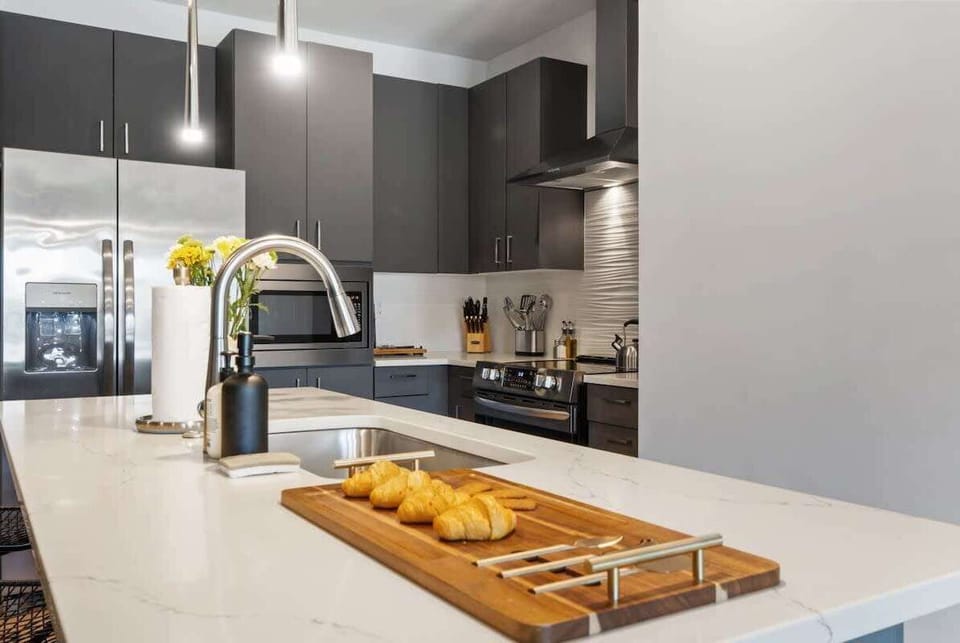 Fully-equipped modern kitchen with a large central island and stainless steel appliances.
