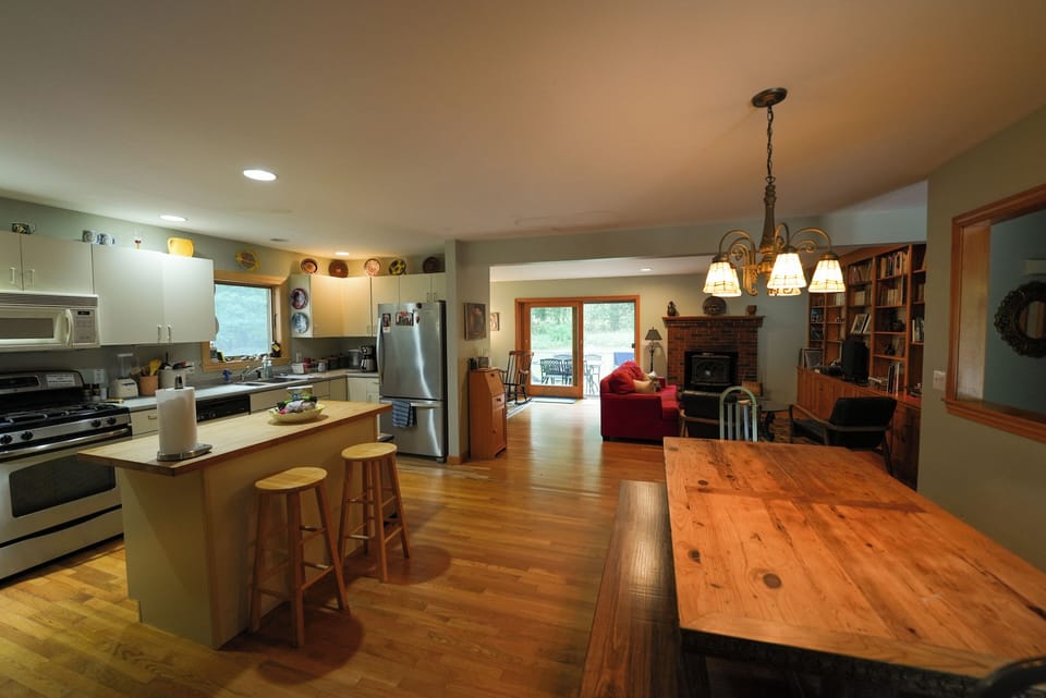 Kitchen and dining area with view of doors to back deck. 