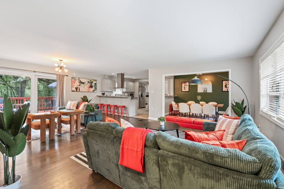 Open‑concept main level where living, dining, and the kitchen connect and flow to the deck.