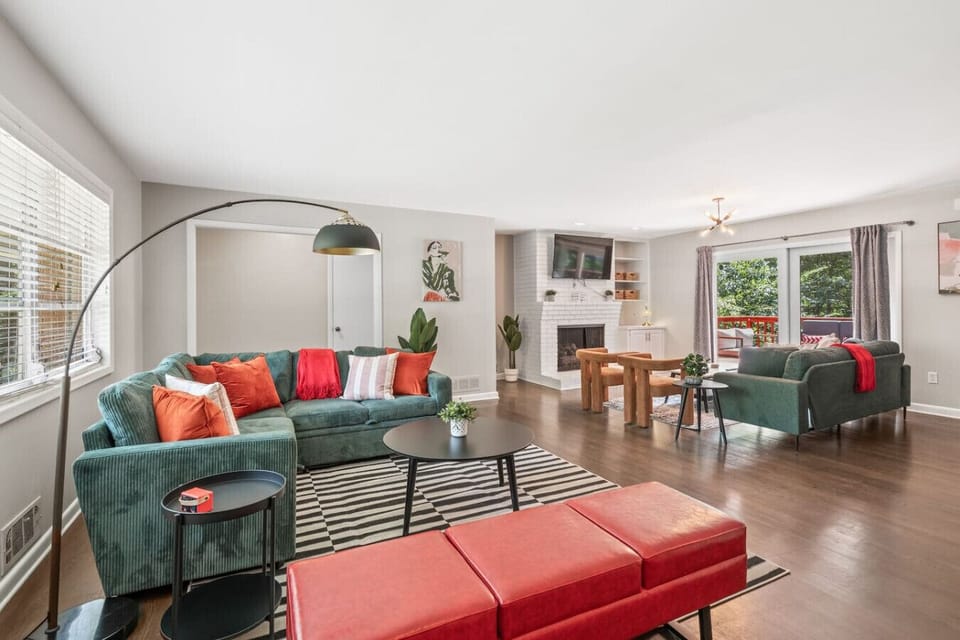 Spacious living room with hardwood floors, white brick fireplace, and sliding doors to the deck.