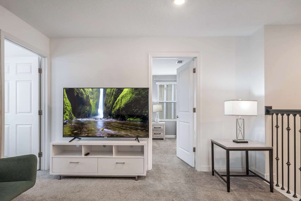 Upper-floor lounge with a large TV and easy access to bedrooms.