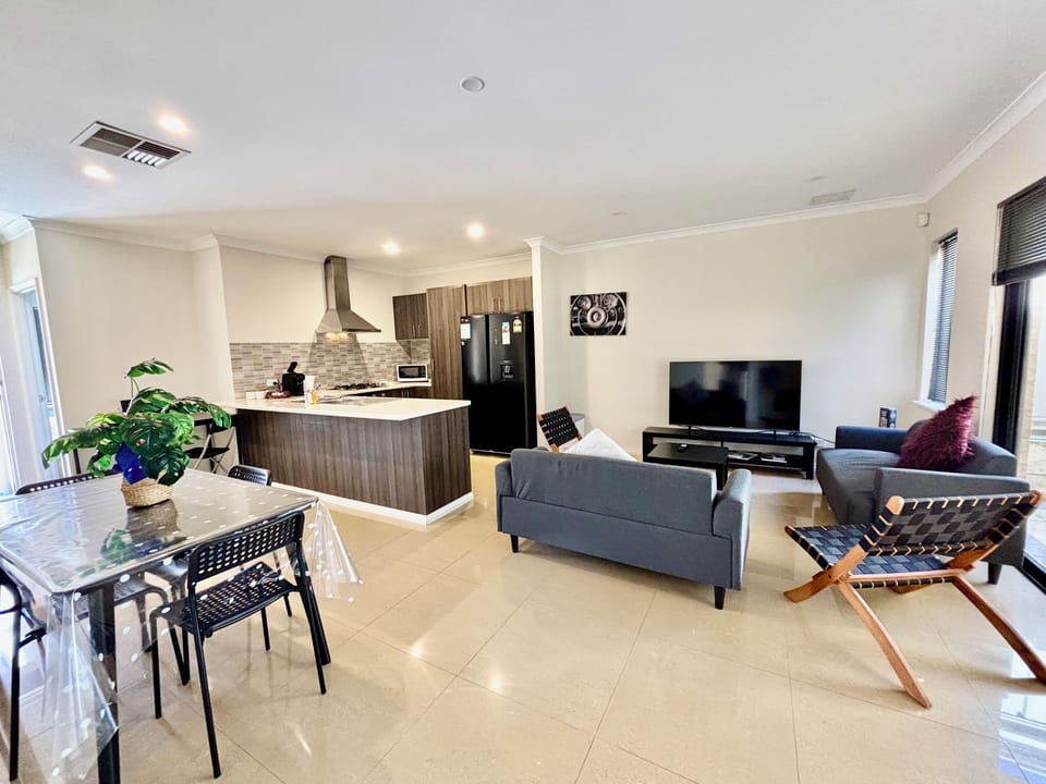 Open concept house with living room attached to kitchen, dining and covered patio. 