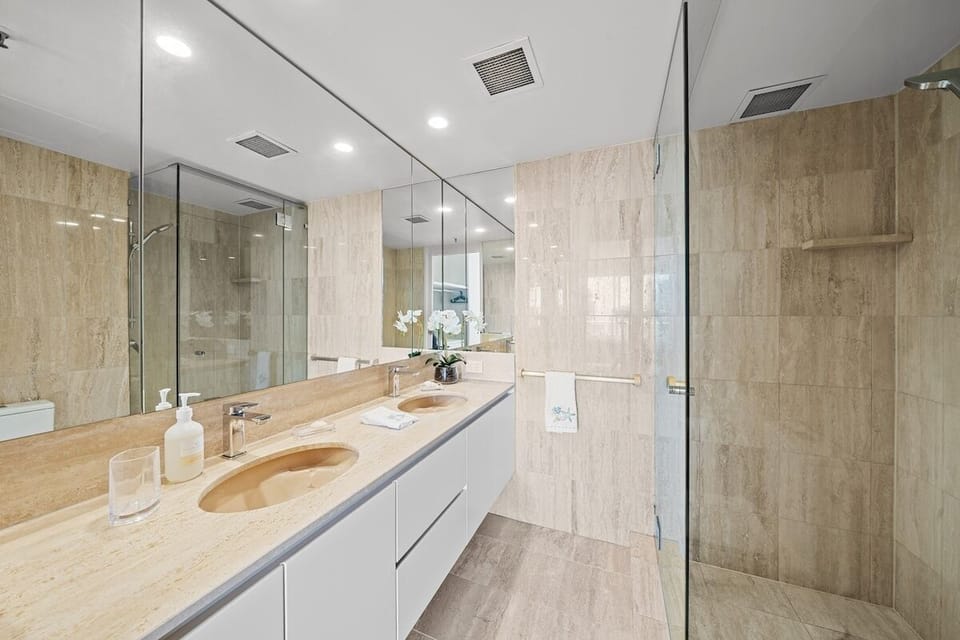 Master ensuite with double sinks, shower, and toilet adjoining the main bedroom.