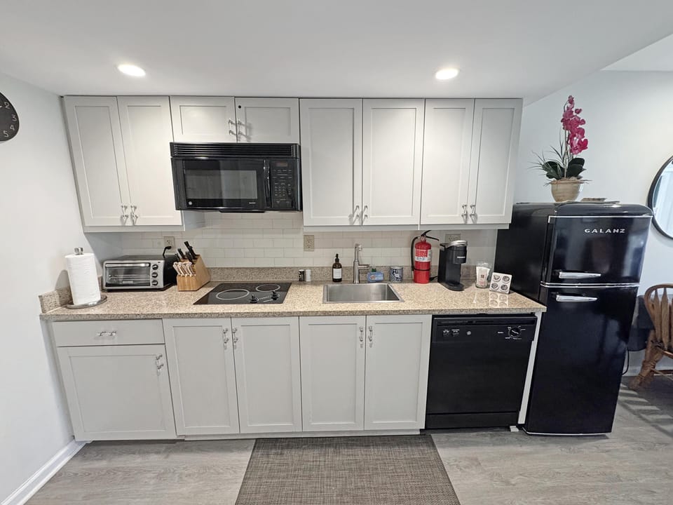 Modern kitchen with sleek appliances and ample counter space with a near full size fridge