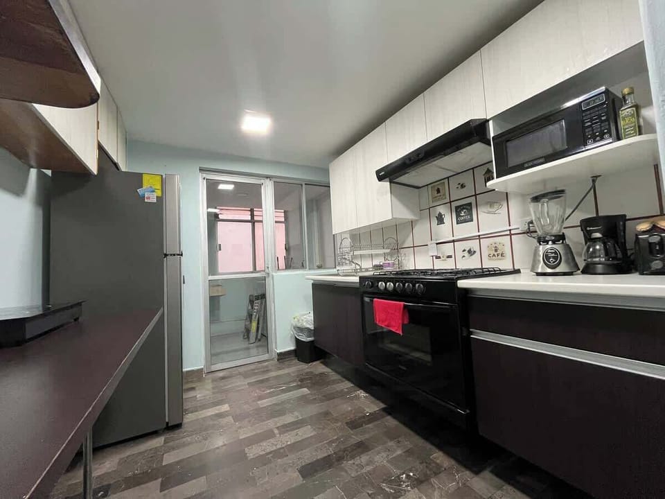 Cocina con estufa, microhondas, cafetera, licuadora, tostador y refrigerador