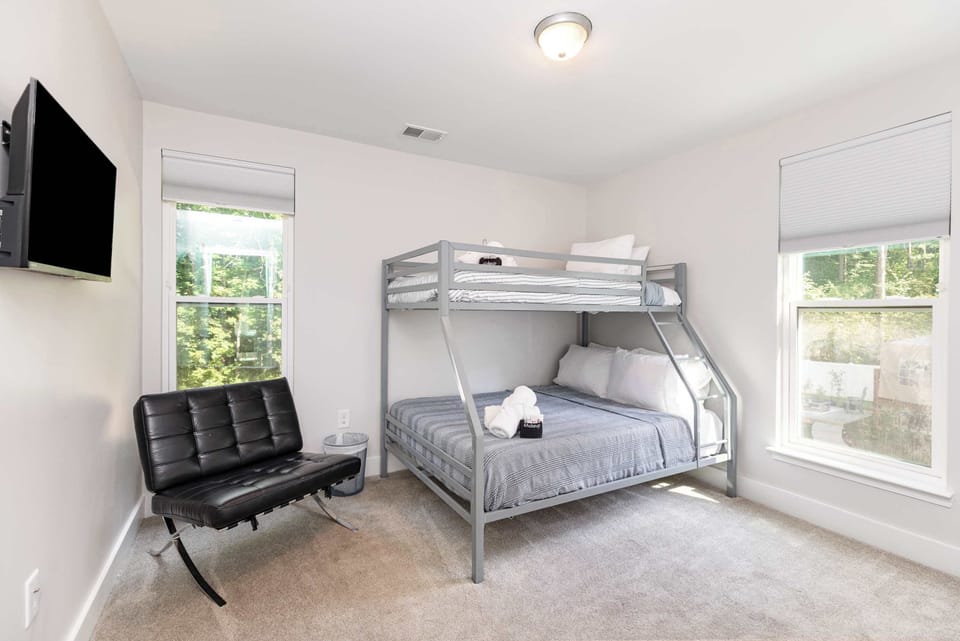Bedroom 4 is located on the second floor and features a Twin over Queen bunk bed as well as a smart TV and luggage racks