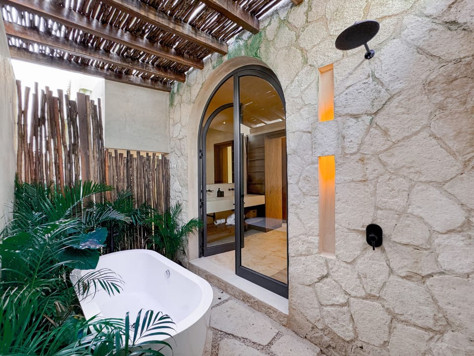 Open-air bathroom with a bathtub paired with a tropical design