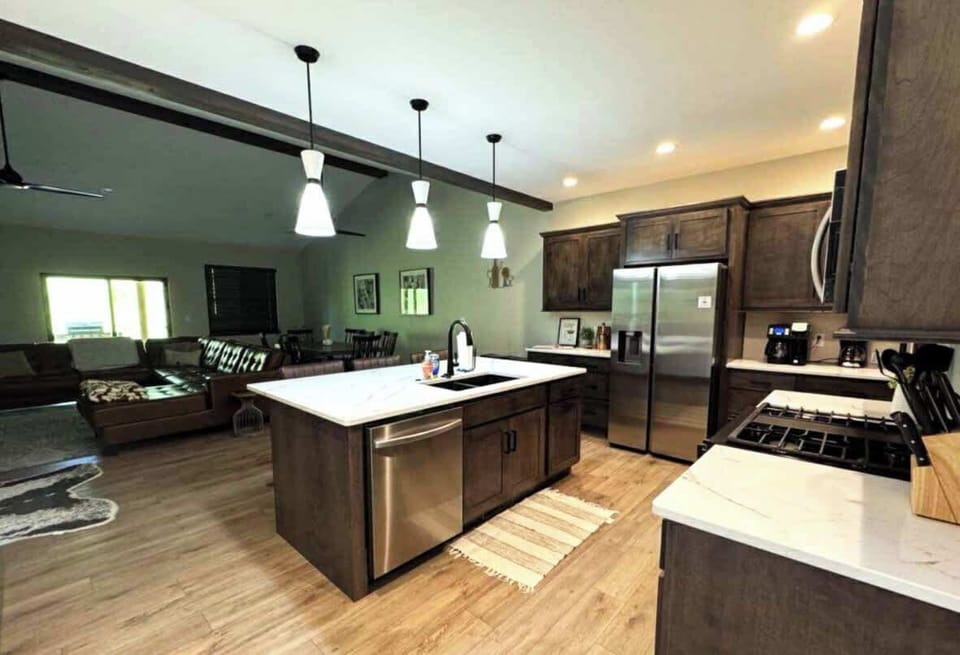 Spacious modern kitchen with quartz countertops, stainless-steel appliances, and pendant lighting. Fully stocked for cooking and dining, it opens seamlessly into the living and dining area—perfect for gathering and entertaining.