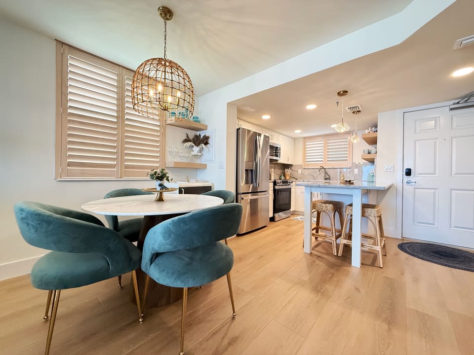 Cook and dine in style with this modern kitchen featuring stainless steel appliances, a cozy breakfast bar, and a chic dining area—perfect for enjoying meals after a relaxing day at the beach.