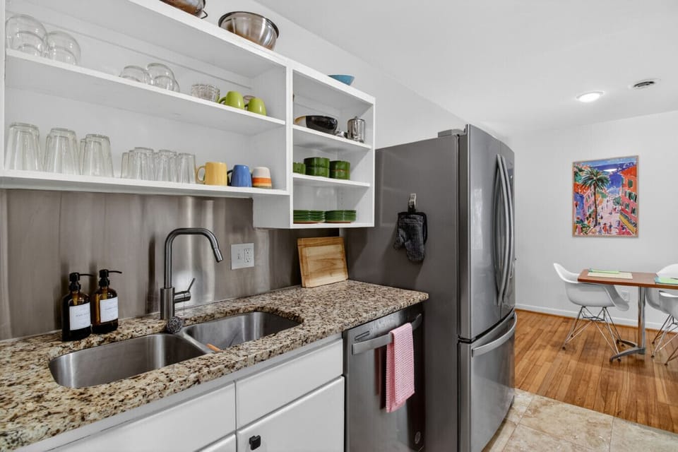 Unit 1 — Fully stocked kitchen with open shelving, stainless appliances, and everything you need for a home cooked meal