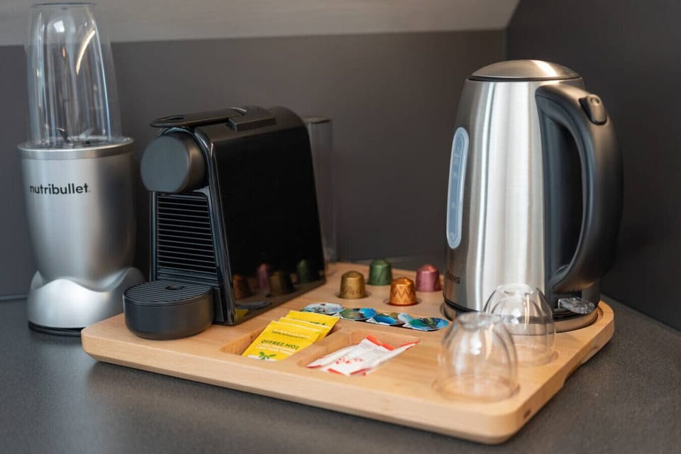 A practical setup with a Nespresso machine, kettle, blender, glasses, coffee capsules (including decaffeinated), as well as tea, sugar, and cream. All are available free of charge in limited quantities—perfect for enjoyable moments anytime.