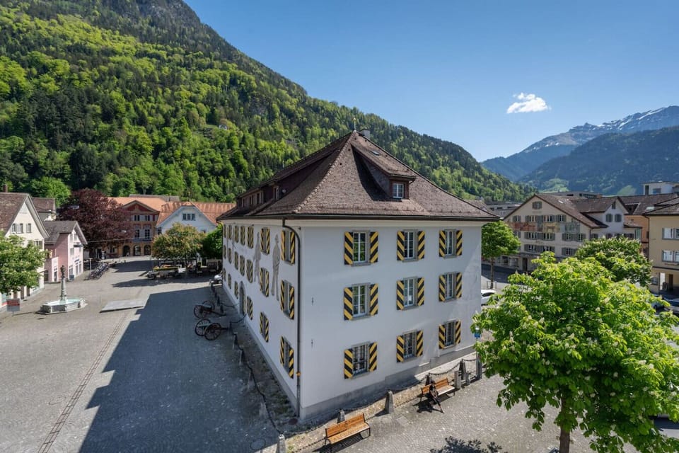 Right in the heart of Altdorf, the view from the bedroom offers an impressive backdrop of the village square, historic facades, and the surrounding mountain landscape – a picturesque panorama in every season.