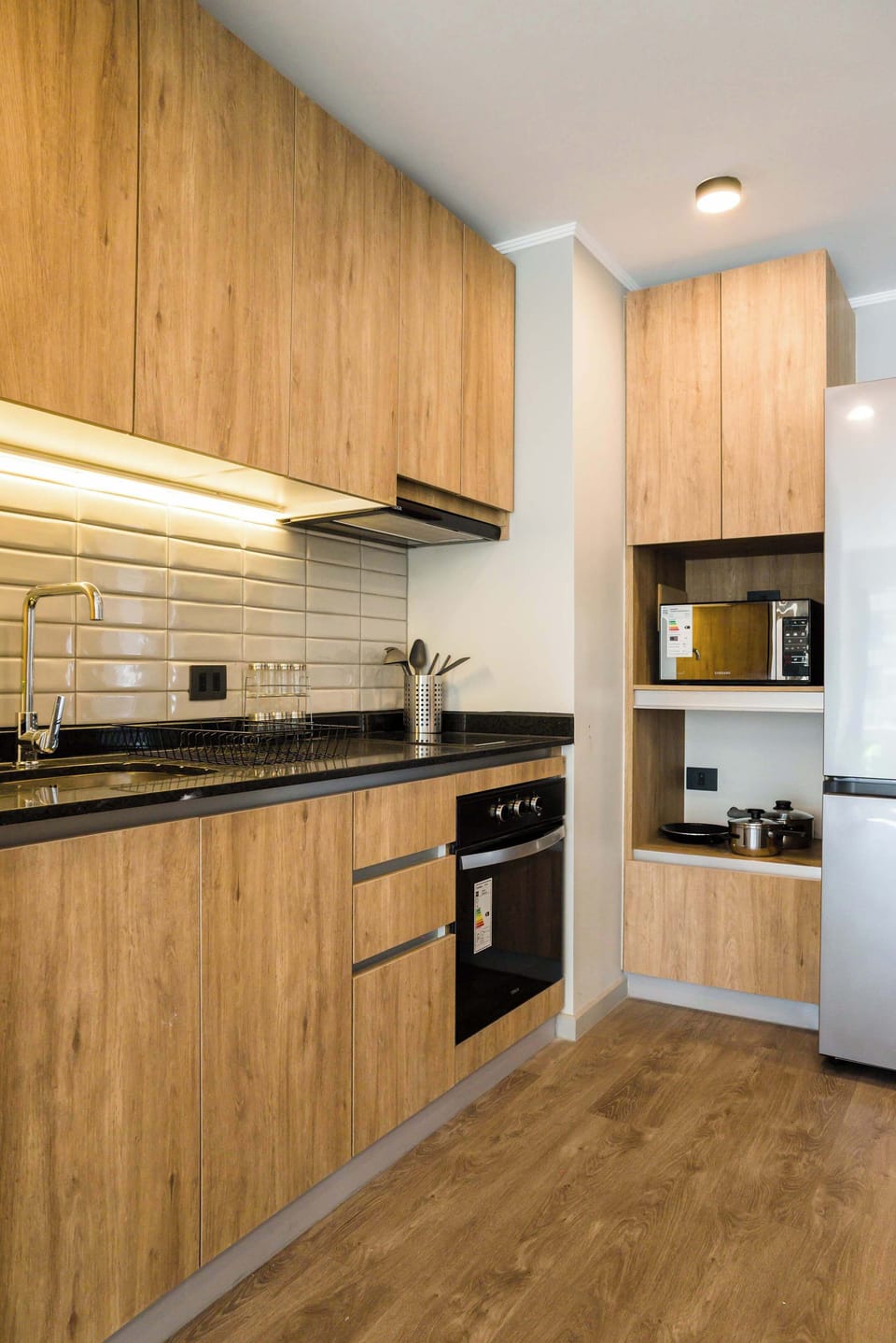 Sleek and modern kitchen with top-notch appliances and stylish wooden cabinetry, perfect for culinary adventures.
