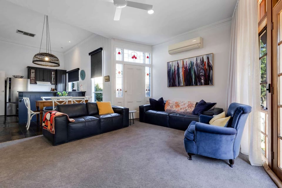 Large lounge room with ample seating, split system, ceiling fan and flat screen TV