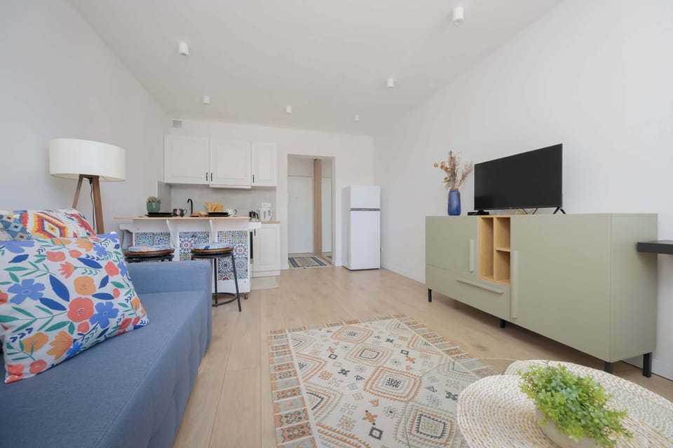The interior seen from the sofa highlights the harmony of design and the easy flow towards the kitchen.