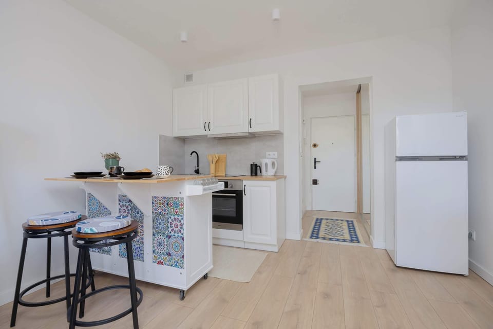 A modern kitchen with an island and high stools creates a functional spot for quick meals.