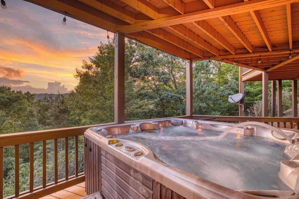Relax in a 6-person hot tub, covered deck, and mountain sunset views.