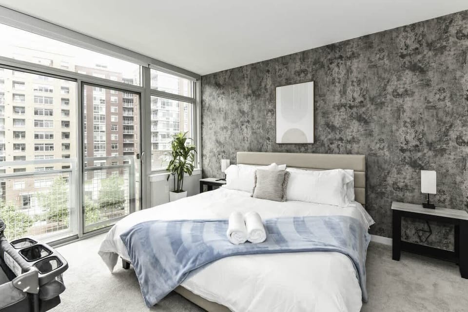 Bedroom 1 with cozy king bed, pack n play crib, flat-scrteen TV and large windows