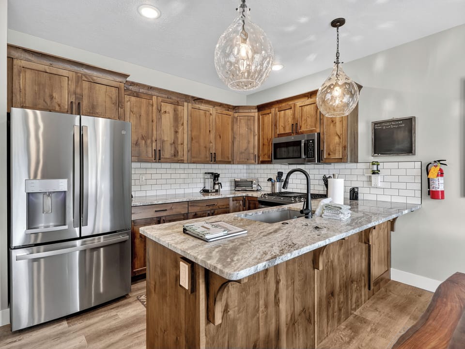 Fully stocked kitchen with sleek stainless steel appliances, custom cabinetry, and beautiful countertops—perfect for preparing meals and gathering together