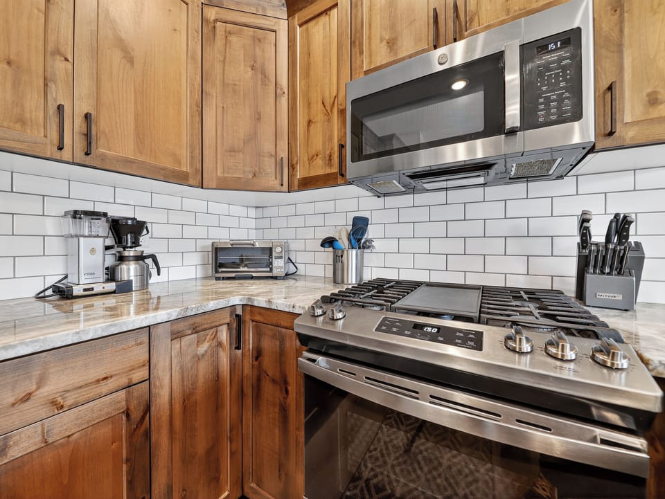 Fully stocked kitchen with sleek stainless steel appliances, custom cabinetry, and beautiful countertops—perfect for preparing meals and gathering together