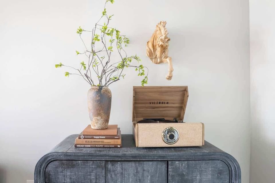 Console table styled with a vintage radio, stacked books, and a small plant