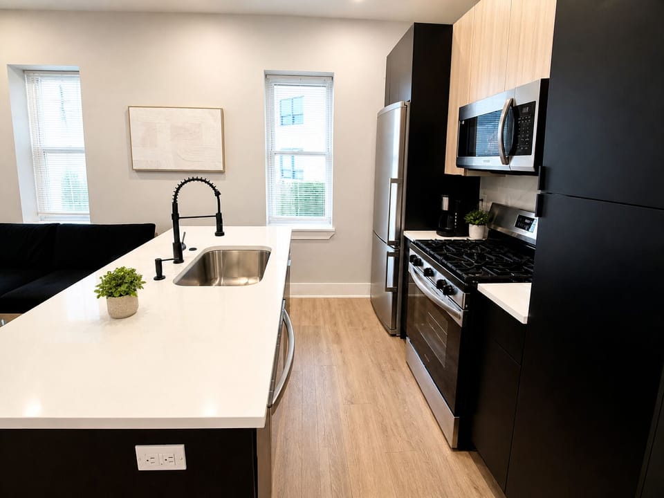 Modern fully equipped kitchen with island seating, stainless steel appliances, microwave, stove, fridge, and all essentials for cooking and dining.