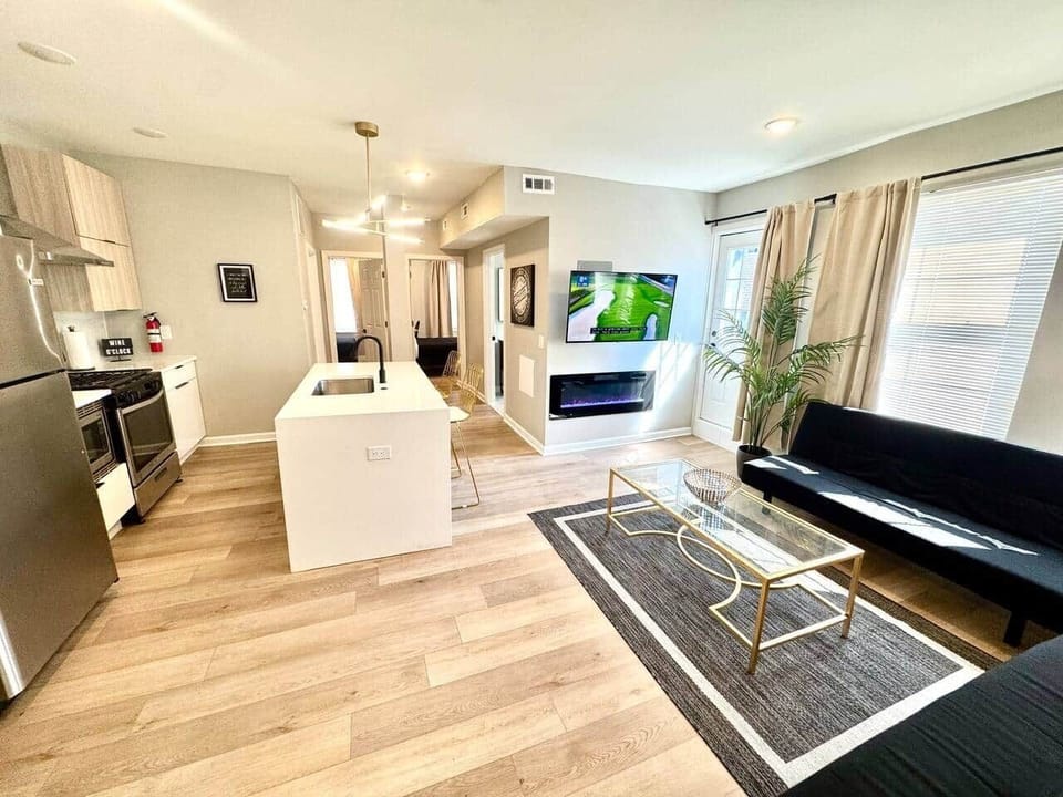 Discover a beautifully decorated living room featuring two sofas, a cozy bed, and a charming fireplace. This inviting space includes a large flat-screen TV & convenient access to a balcony that connects to the kitchen, great relaxation &entertaining.