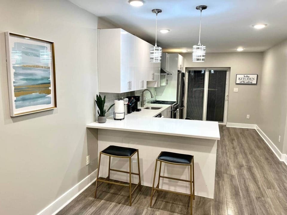 Large kitchen with a quartz island, a large 36-inch refrigerator, a professional oven hood, a microwave, and a coffee maker.
Back door leading to the backyard.