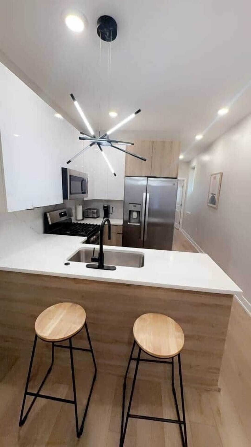 Modern kitchen featuring a quartz breakfast bar, double-door refrigerator, microwave, dishwasher, and oven range, fully stocked with essential cookware and utensils. Perfect for all your culinary needs!
Connected to
Living room and dining room.