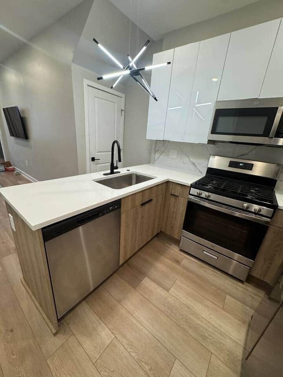 Modern kitchen featuring a quartz breakfast bar, double-door refrigerator, microwave, dishwasher, and oven range, fully stocked with essential cookware and utensils. Perfect for all your culinary needs!
Connected to
Living room and dining room.