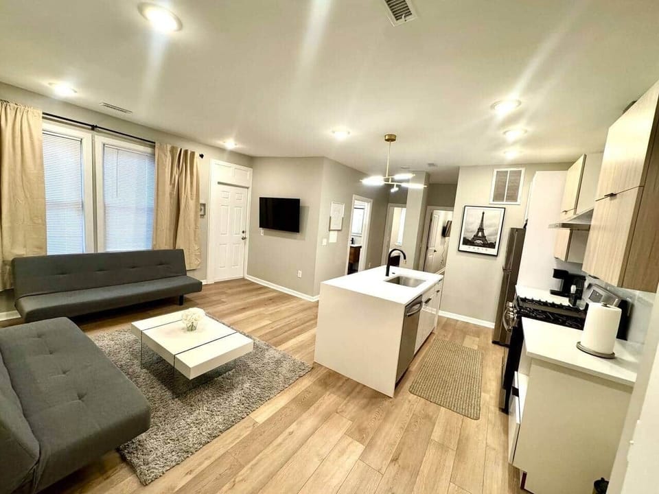spacious living room! It features 2 futon sofa beds, perfect for accommodating extra guests. Enjoy your favorite shows on the 50-inch TV,  Cozy up by the fireplace underneath for a warm atmosphere. There’s a door that leads to a small balcony outside