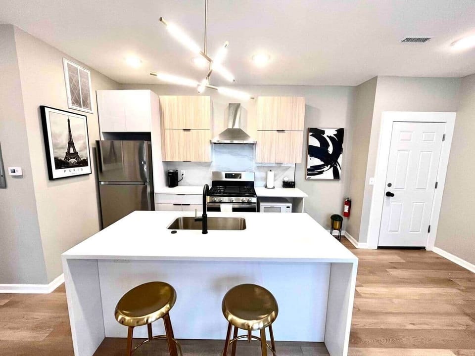 A fully equipped kitchen, including a beautiful waterfall quartz breakfast bar. You'll have access to a range with a hood, a microwave, a dishwasher, a refrigerator, and a garbage disposal, making it convenient for all your cooking and dining needs