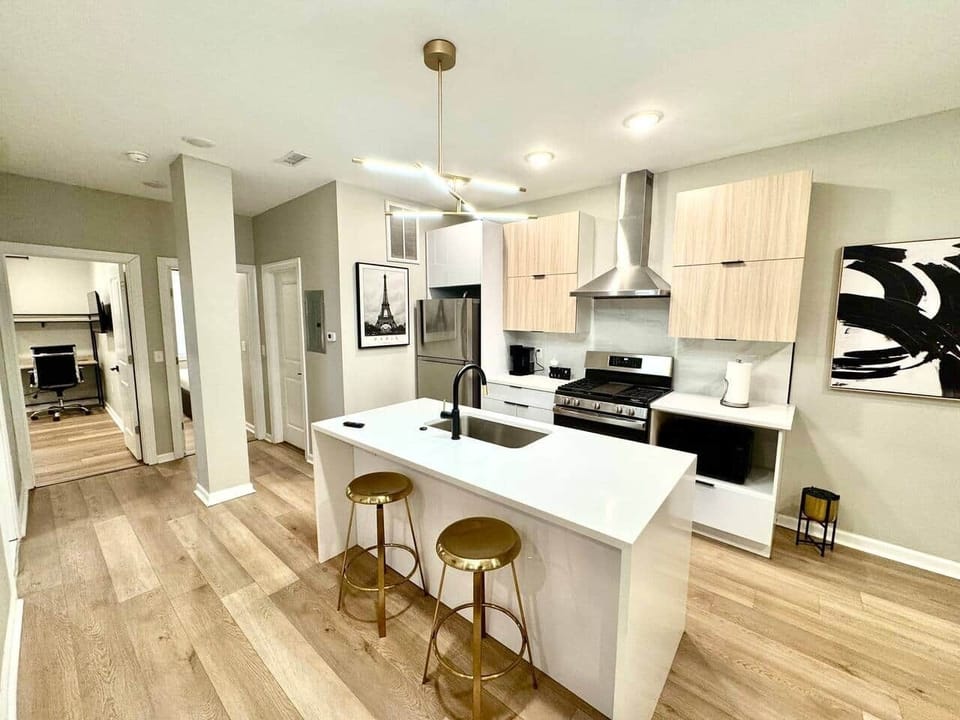A fully equipped kitchen, including a beautiful waterfall quartz breakfast bar. You'll have access to a range with a hood, a microwave, a dishwasher, a refrigerator, and a garbage disposal, making it convenient for all your cooking and dining needs