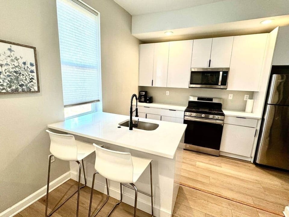 

"Enjoy a fully equipped kitchen featuring an island bar with two stools, complete with an oven, stove, microwave, and refrigerator. You'll find all the cookware, silverware, and dishes you need for a perfect