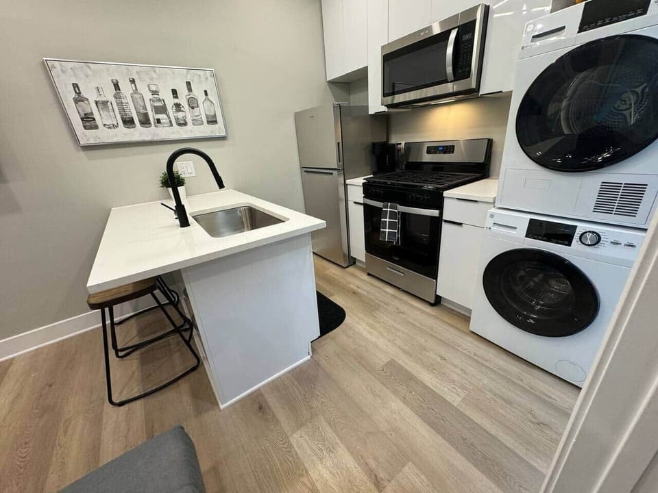 This beautiful kitchen, where you’ll find a quartz island with bar stools, perfect for enjoying meals or hanging out with friends. The kitchen is equipped with a refrigerator, microwave, and dishwasher, along with all the basic cooking essential.