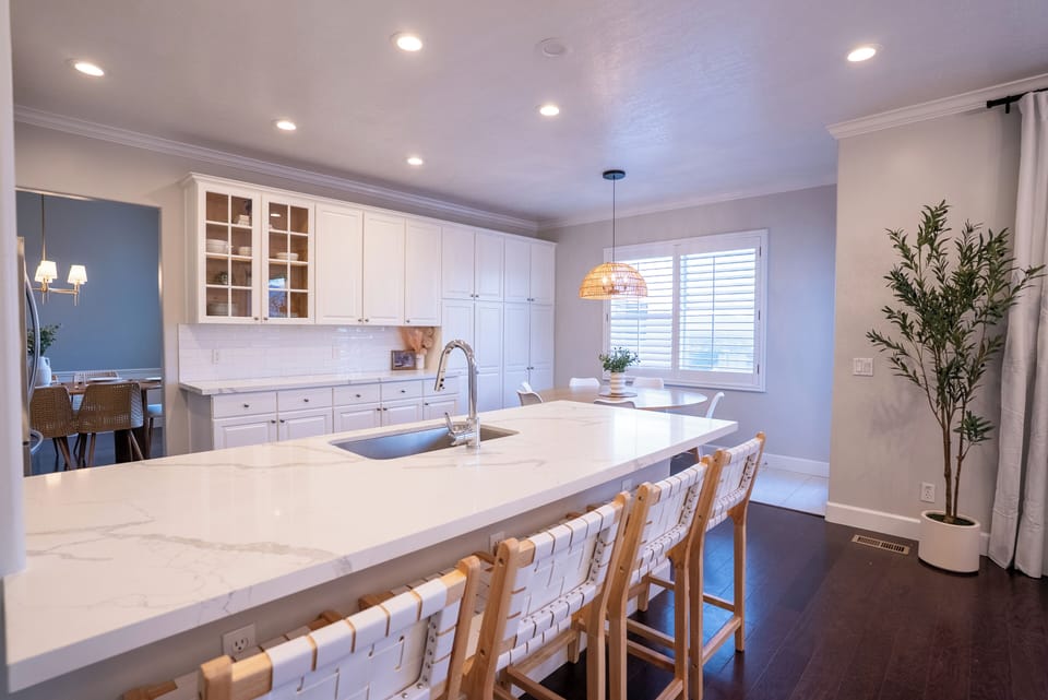 Prep meals in our clean kitchen with white cabinets, marble quartz countertops, and stainless steel appliances.