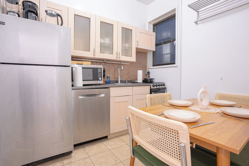 Modern kitchen & dining area with stainless steel appliances & seating w four