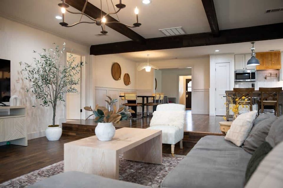 Open-concept living area with cozy seating, stylish beams, and modern touches—perfect for relaxing or entertaining. Flows seamlessly into the dining and kitchen areas