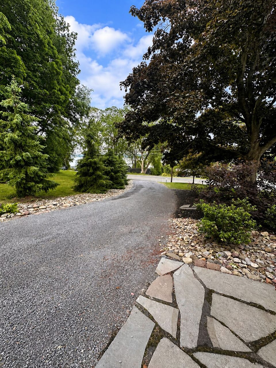 Driveway leading to the house with lake views in the distance.