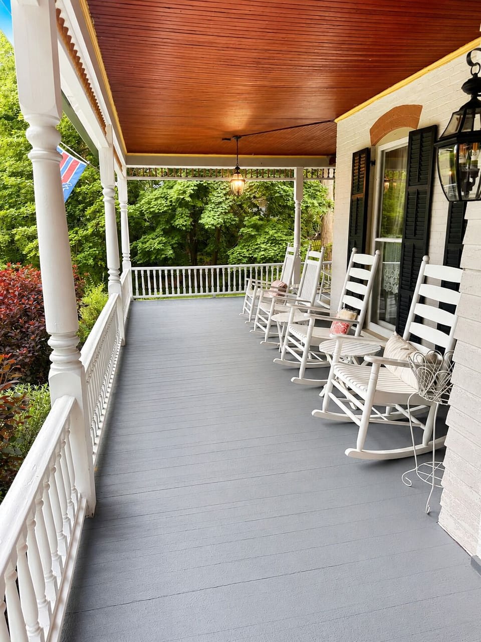 Front porch seating with rocking chairs and covered lake-view space.