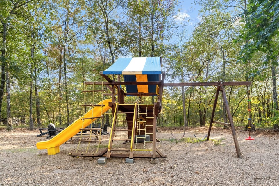 Colorful backyard playset with swings, slide, and climbing features, an outdoor adventure space designed for kids to play and explore.  Sorry Dad, this is for kids only.