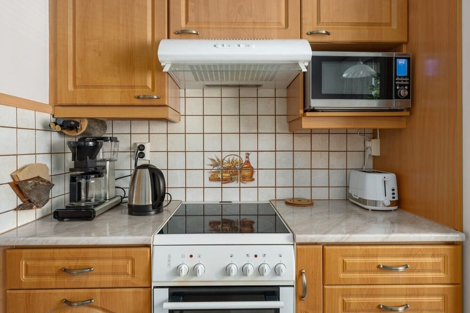 Kitchen counter with the stove, coffee maker and electric kettle all within reach.