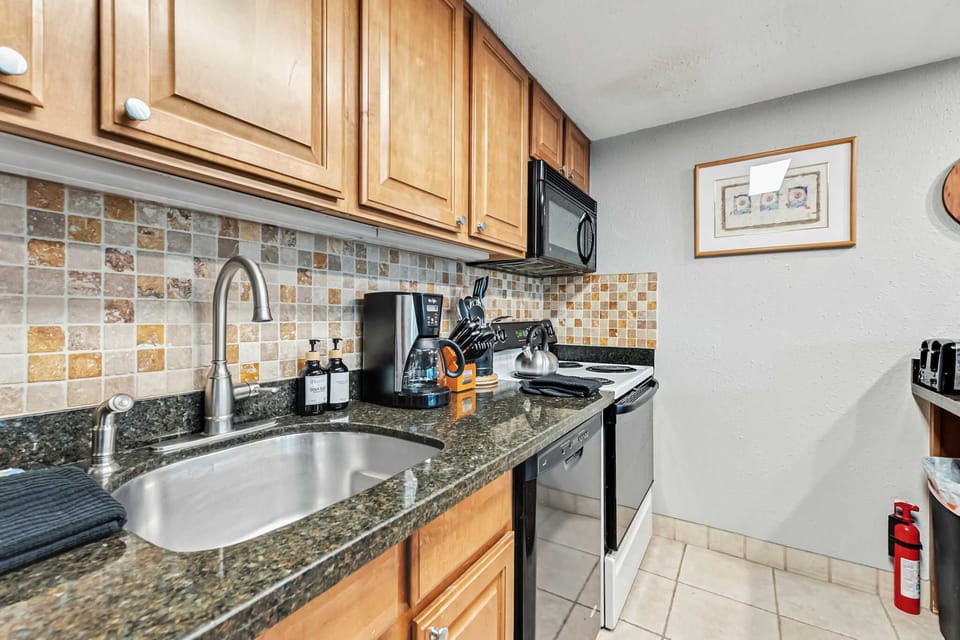 Kitchen: Drip coffee maker, blender, toaster, cooking utensils, tableware