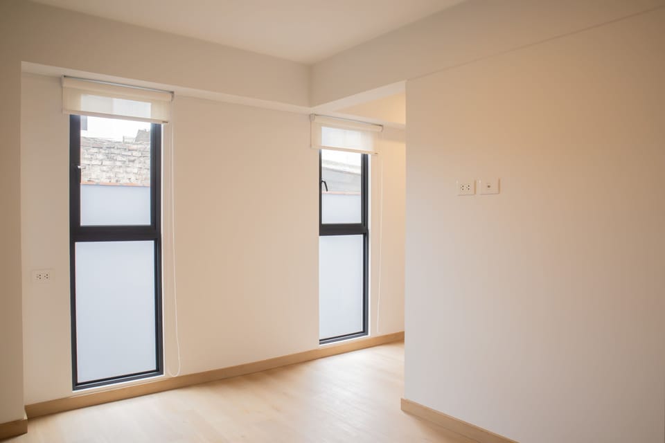 Bright and empty room with large windows and natural light.