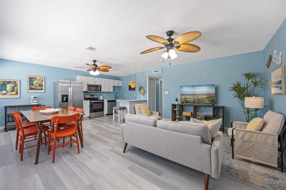 Open-concept living area with coastal blue walls and modern kitchen appliances.