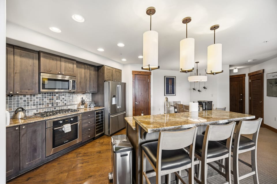 Chef's Kitchen: Granite Island, Gas Range & Dining Room Beyond
