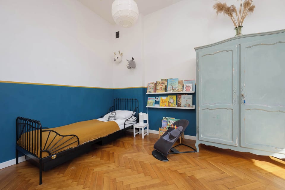 The space with a large wardrobe, bed and toys is functional and supports children’s daily activities.