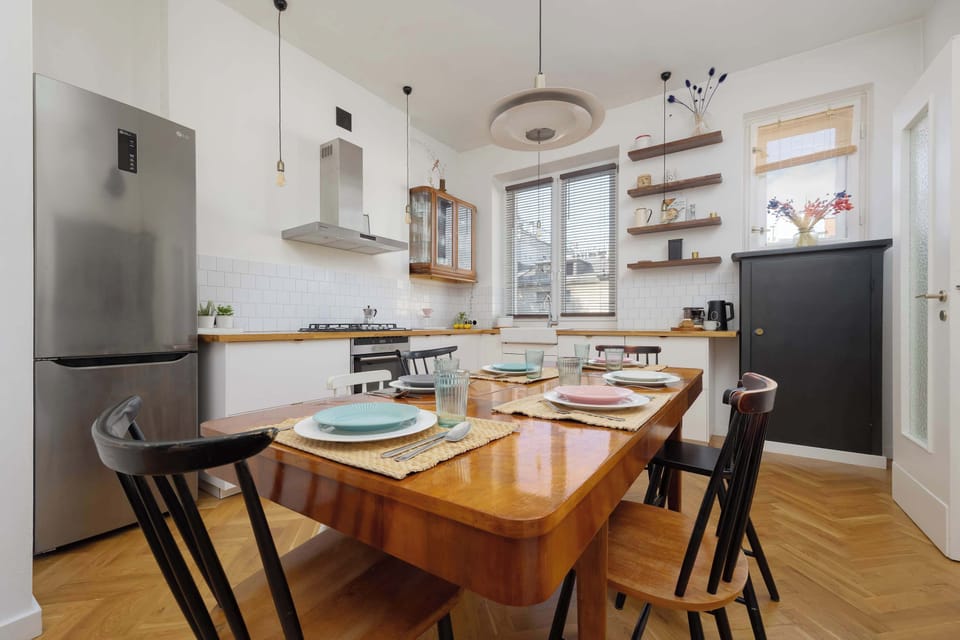 The kitchen table surrounded by comfortable chairs makes your morning coffee taste especially delightful.