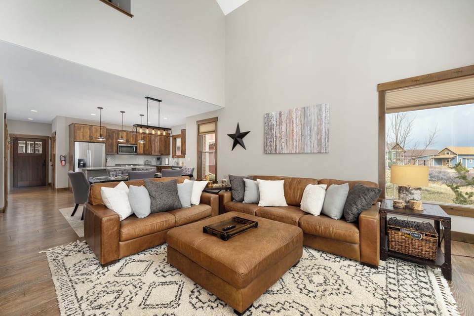 Unwind in your spacious living area with rich leather sectional and stunning natural light streaming through expansive windows.