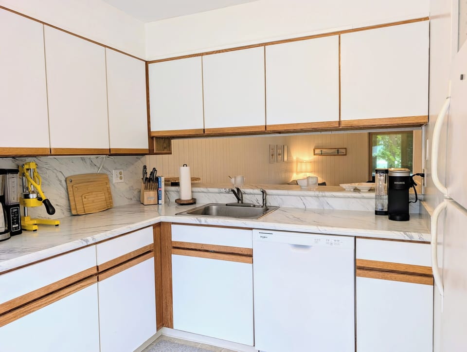 718D Treetop Lane - Stainless Steel Gas Range - The primary cooking area features a sleek five-burner stainless steel gas stove and oven. The surrounding cabinetry and light-colored flooring create a bright, clean aesthetic consistent with the townhome's comfortable interior design.